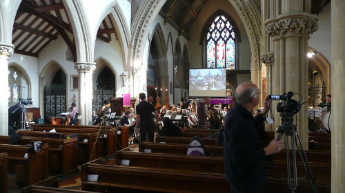 David setting up his camera during rehearsal with images from Kampala projected on the screen