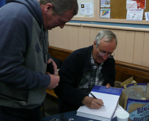 Alex signing copies of his book