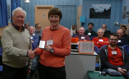 Michael presenting Anne with the shield. Leon and Brian are also in the audience on the right